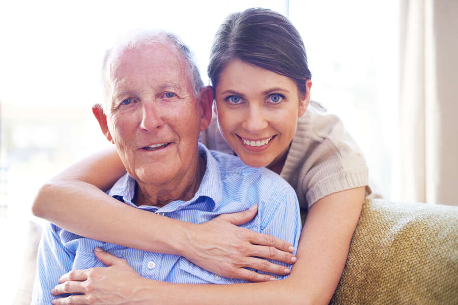 A loving daughter embracing her senior father at the nursing home