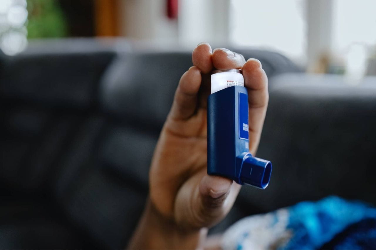 Person holding a blue inhaler