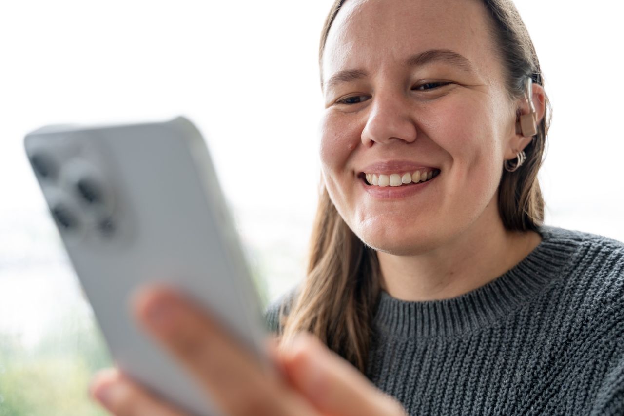 Woman with a hearing aid on a smartphone