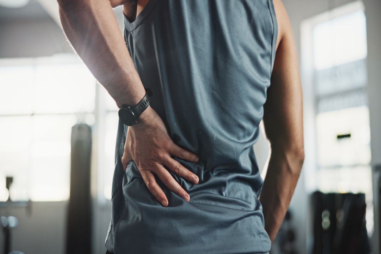 Man holding lower back in pain