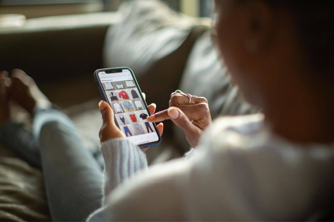 Woman on couch scrolling on her phone