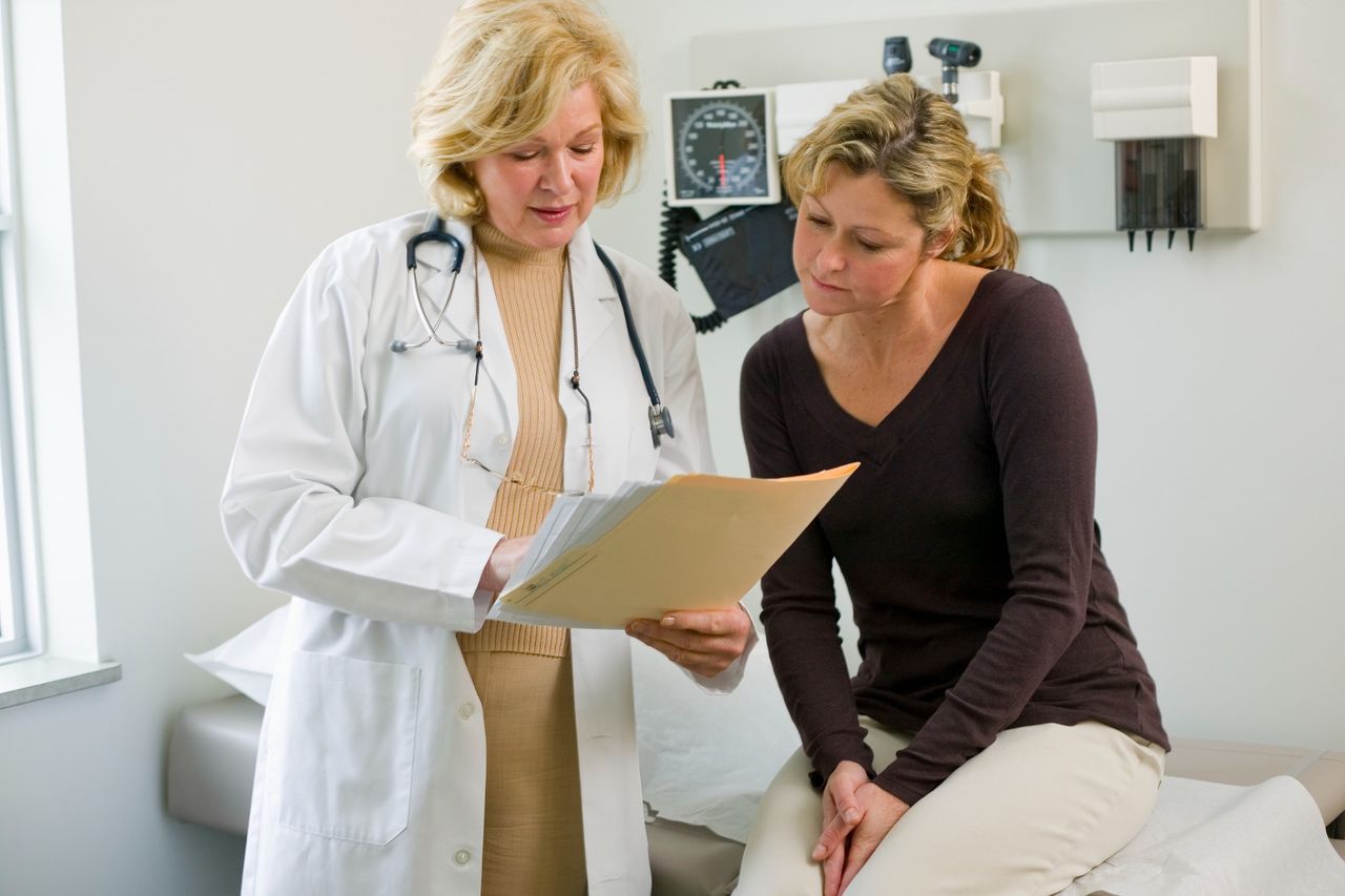 A female doctor discussing paperwork with a patient