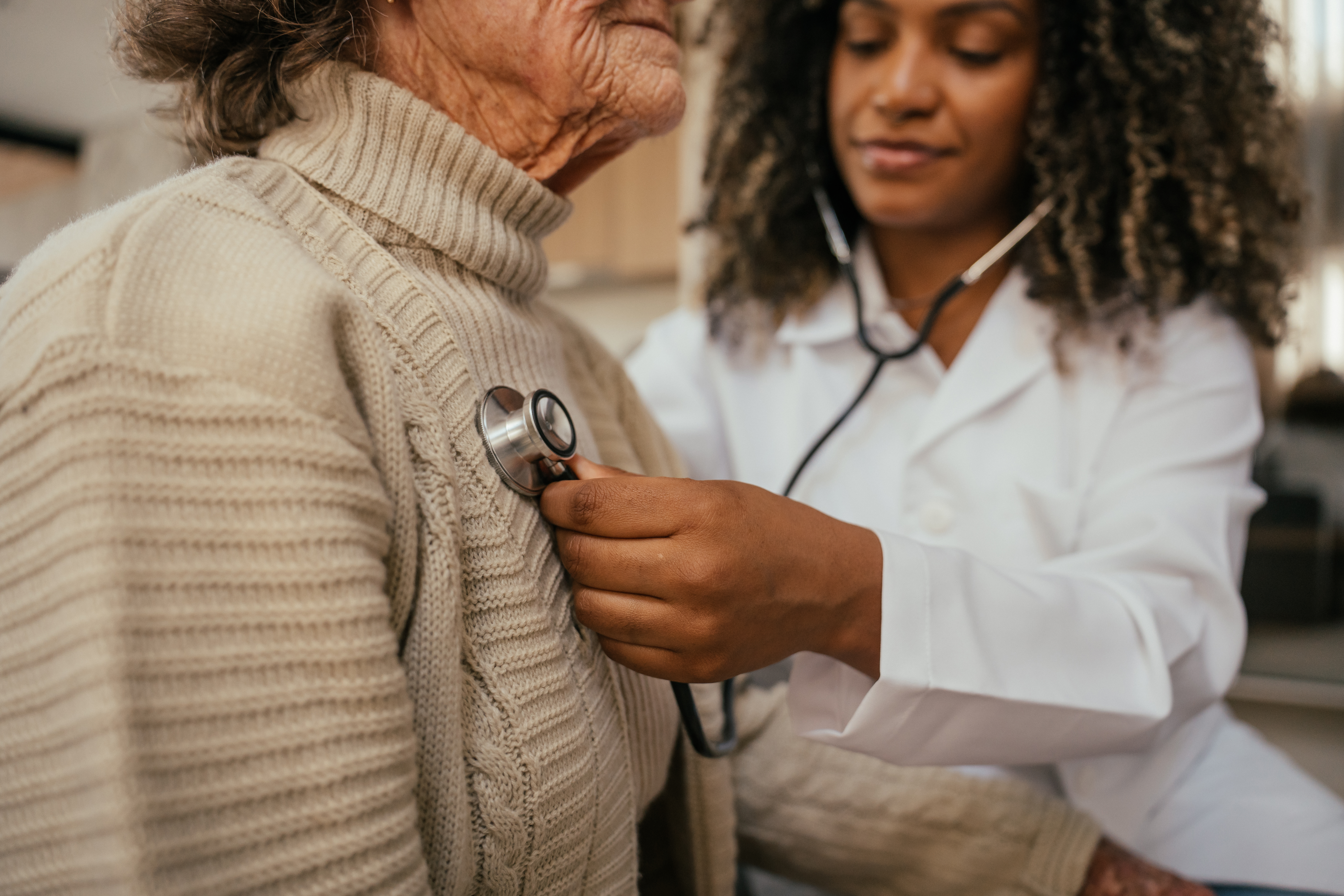 Healthcare worker checking an elderly patient’s heart with a stethoscope