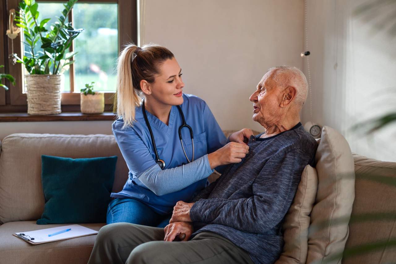 Nurse providing home care and checking on elderly patient