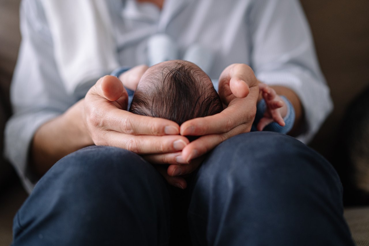 Newborn cradled in hands