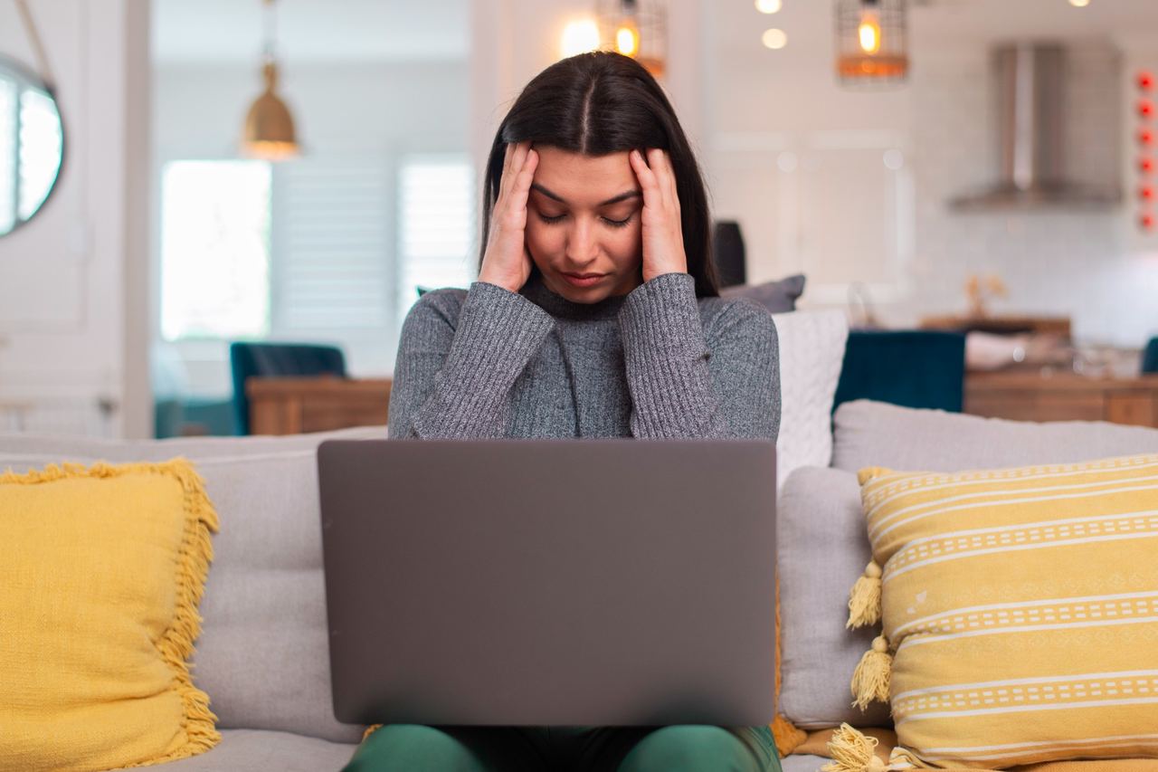 Woman stressed while using a laptop