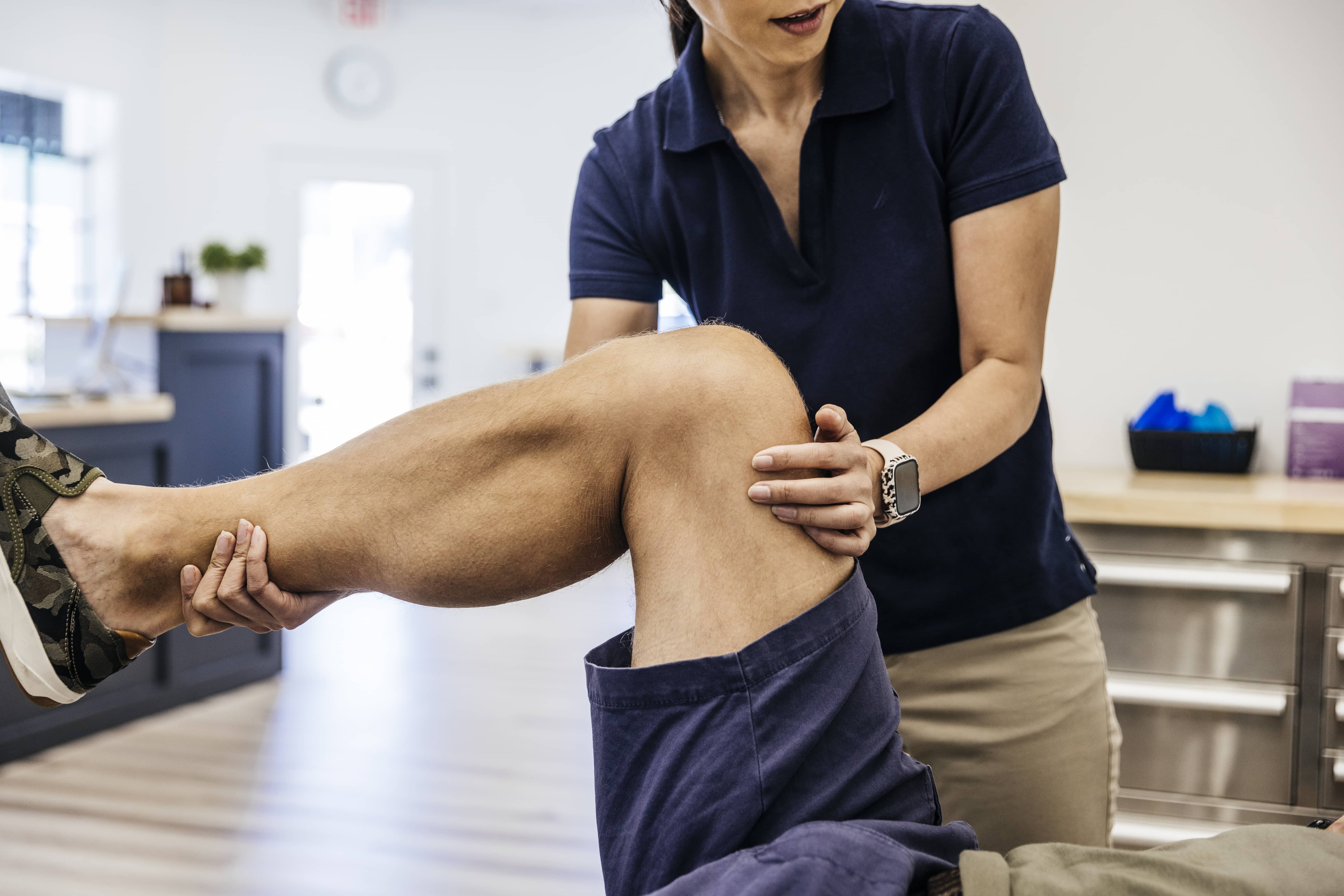 Patient on Physical Therapy Table Doing Leg Exercises for the Knee