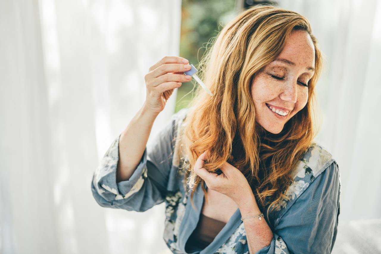 woman applying product to her hair