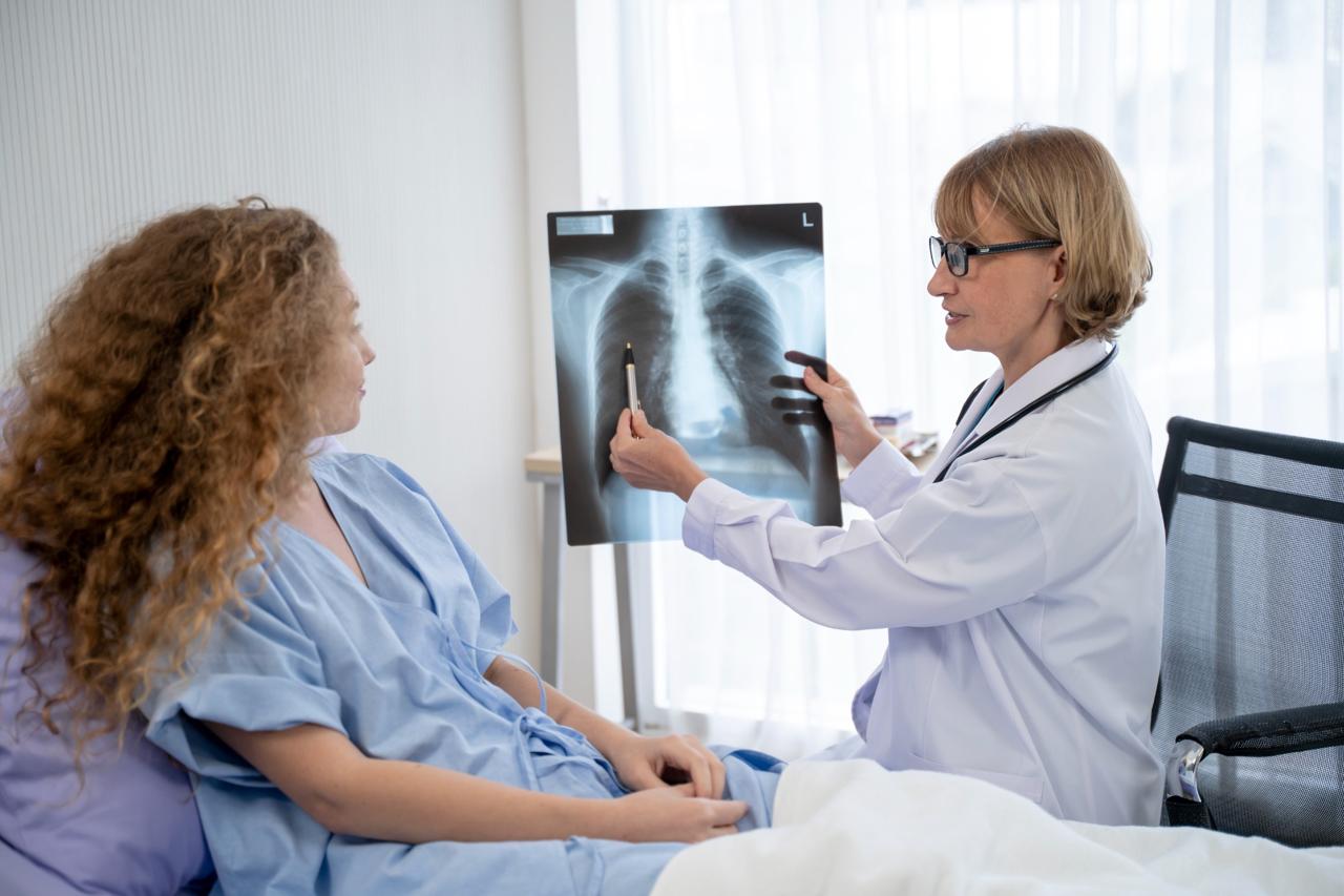 Woman doctor points out details of a chest x-ray to a patient