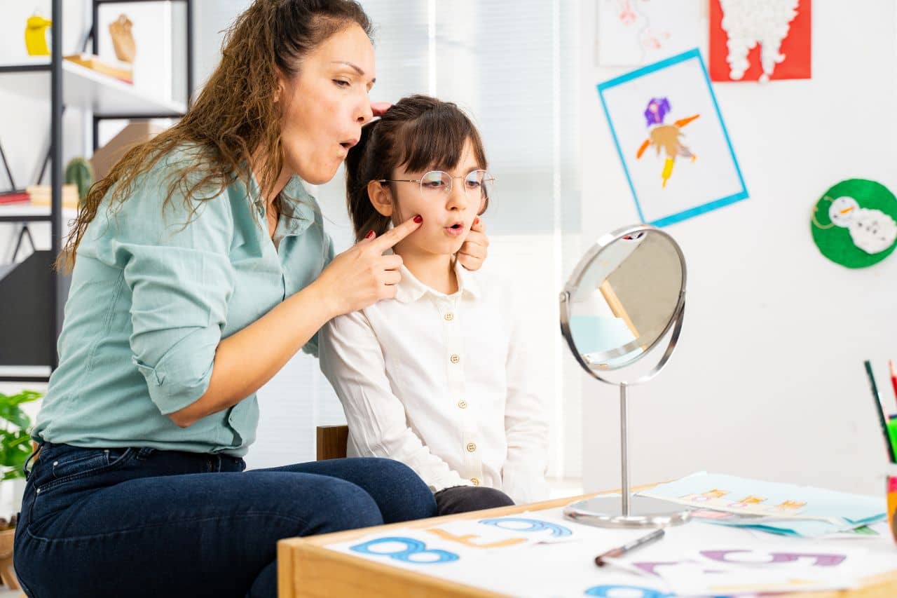 Speech pathologist helping child with lisps