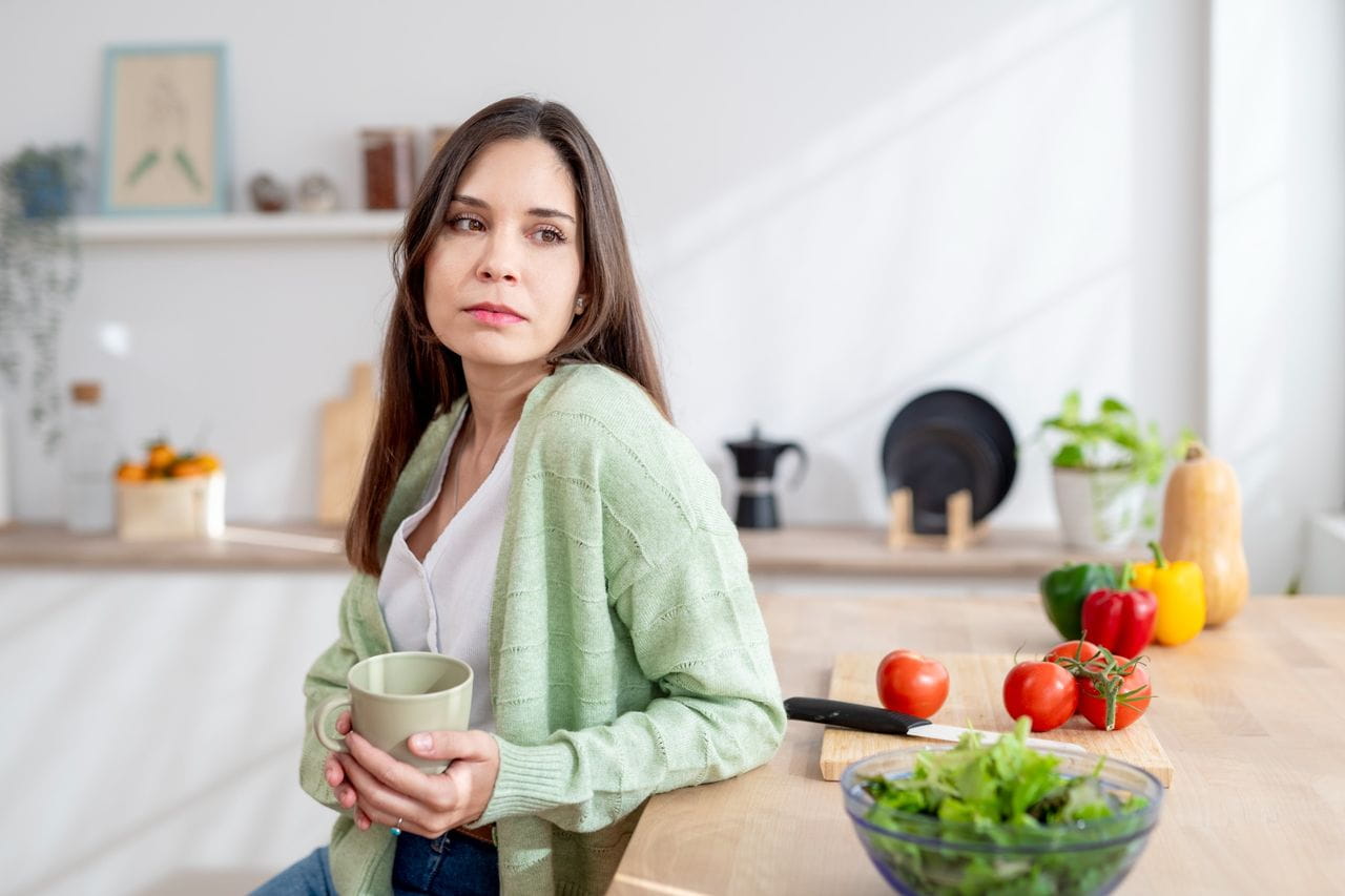 Woman next to coffee and a salad