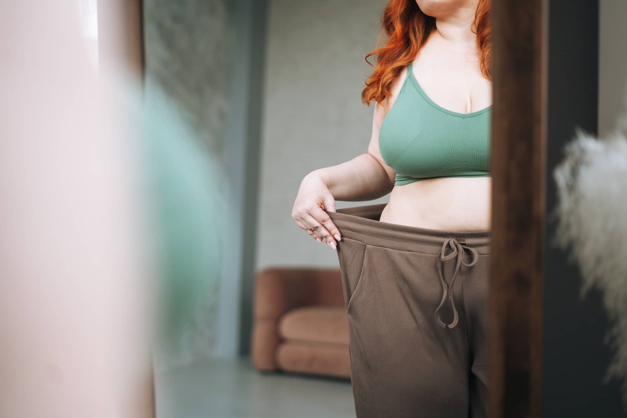 Woman Showing Weight Loss in Larger Pants