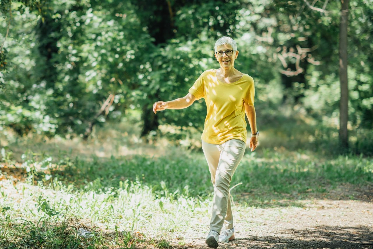 Older woman walking in the woods