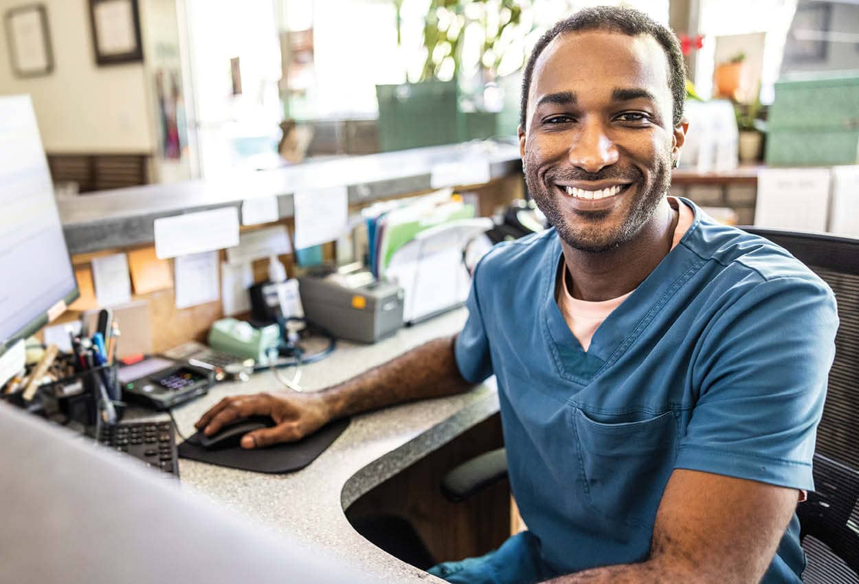 Male nurse smiling at desk