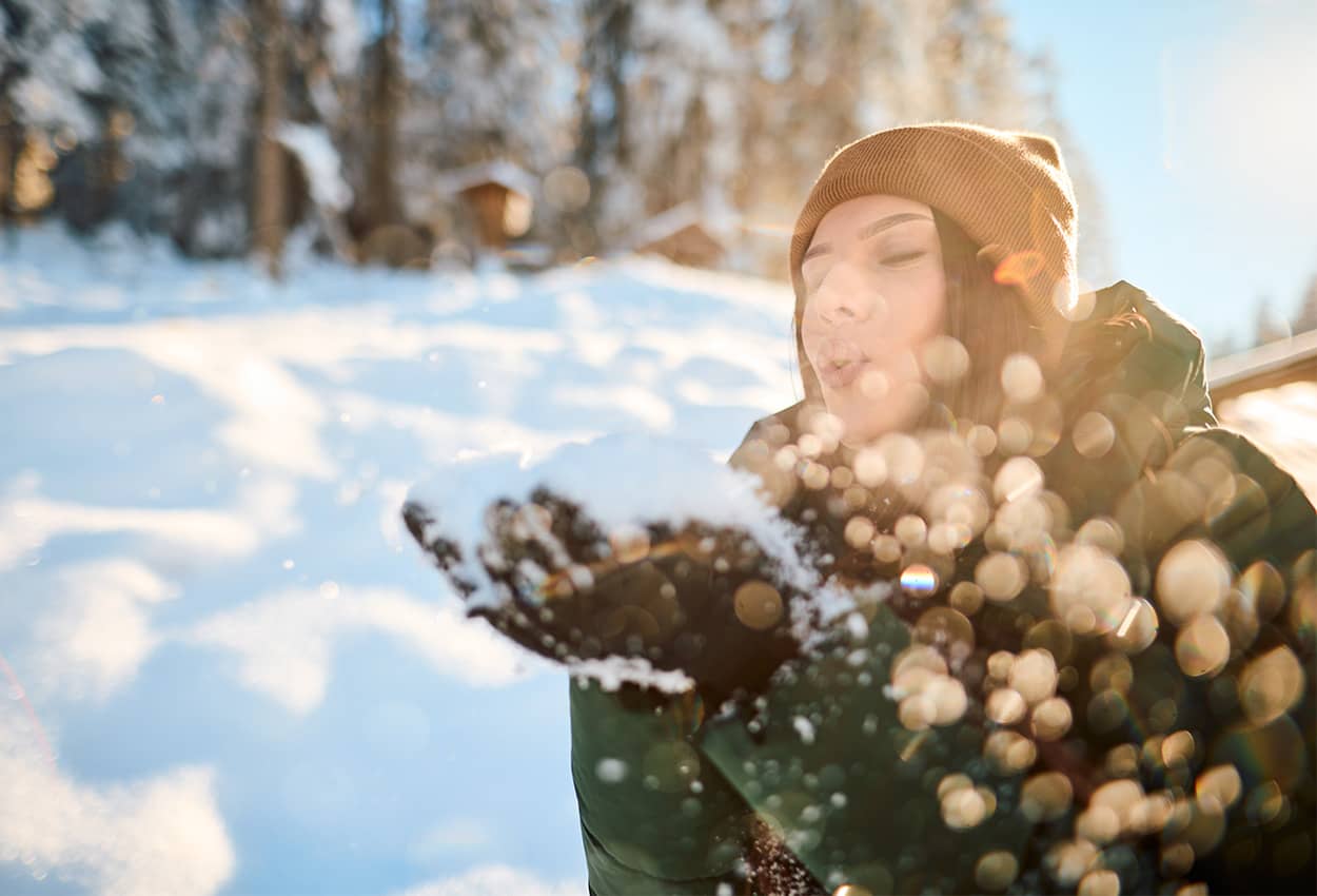 Woman holding snow in wintery outdoors