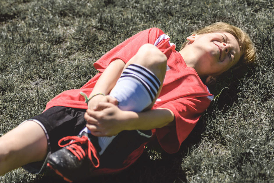 Boy holding ankle