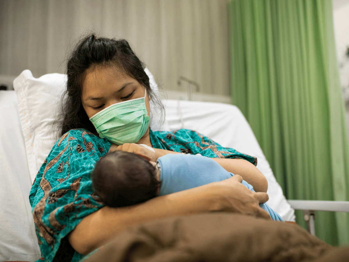 New mother holding her infant in the hospital.