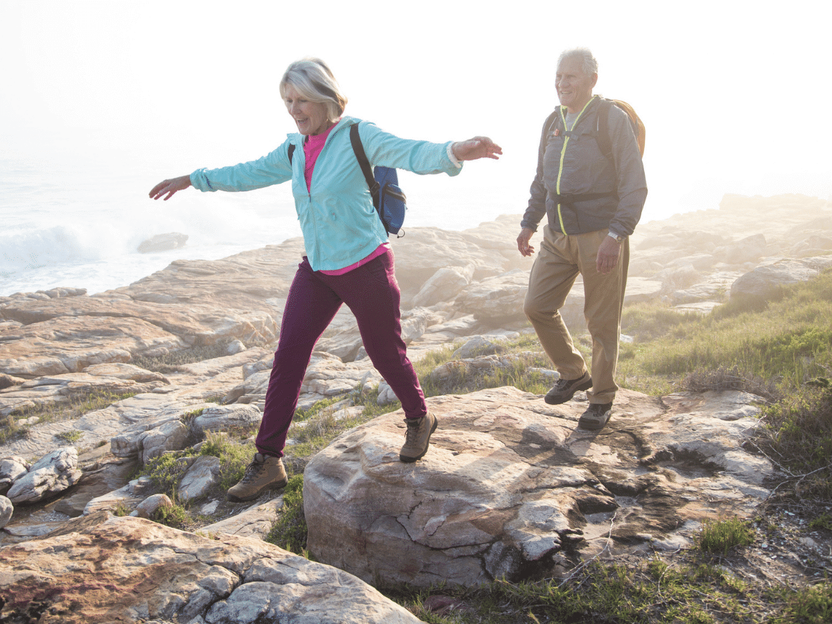 Older couple hiking outside on rocks