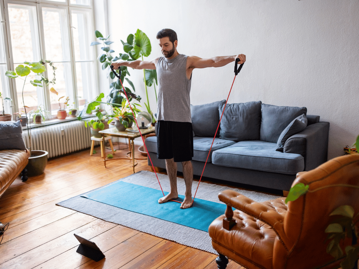Young man exercising in his living room at home.