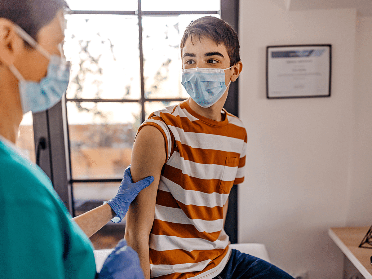 Teenage boy in a doctor's office preparing to receive a vaccine