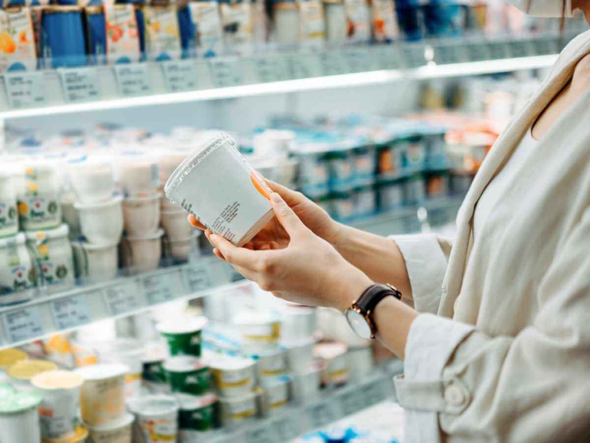 Close up of a woman reading a nutrition label in a grocery store