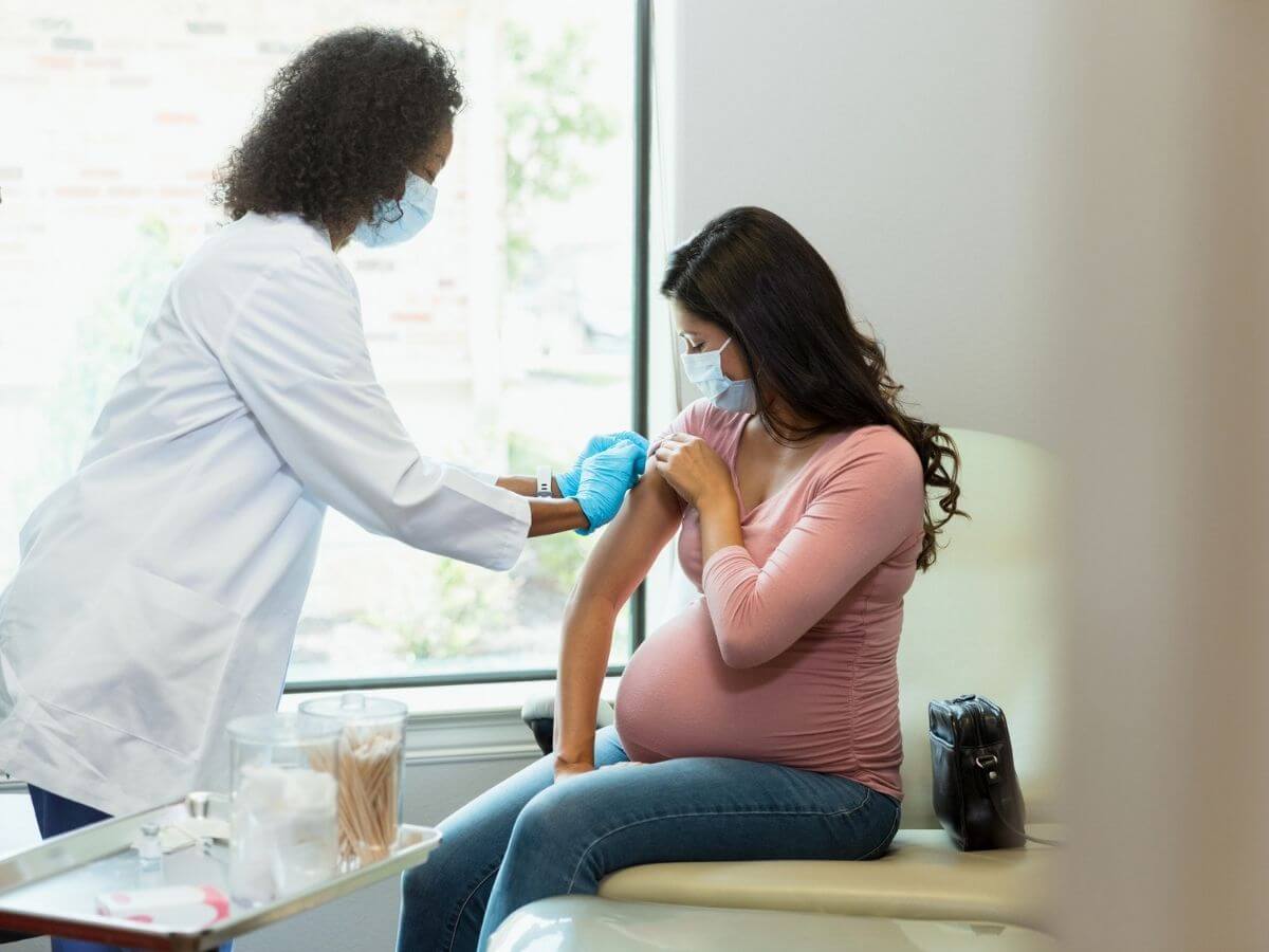 Pregnant woman receiving a vaccination at the doctor's office