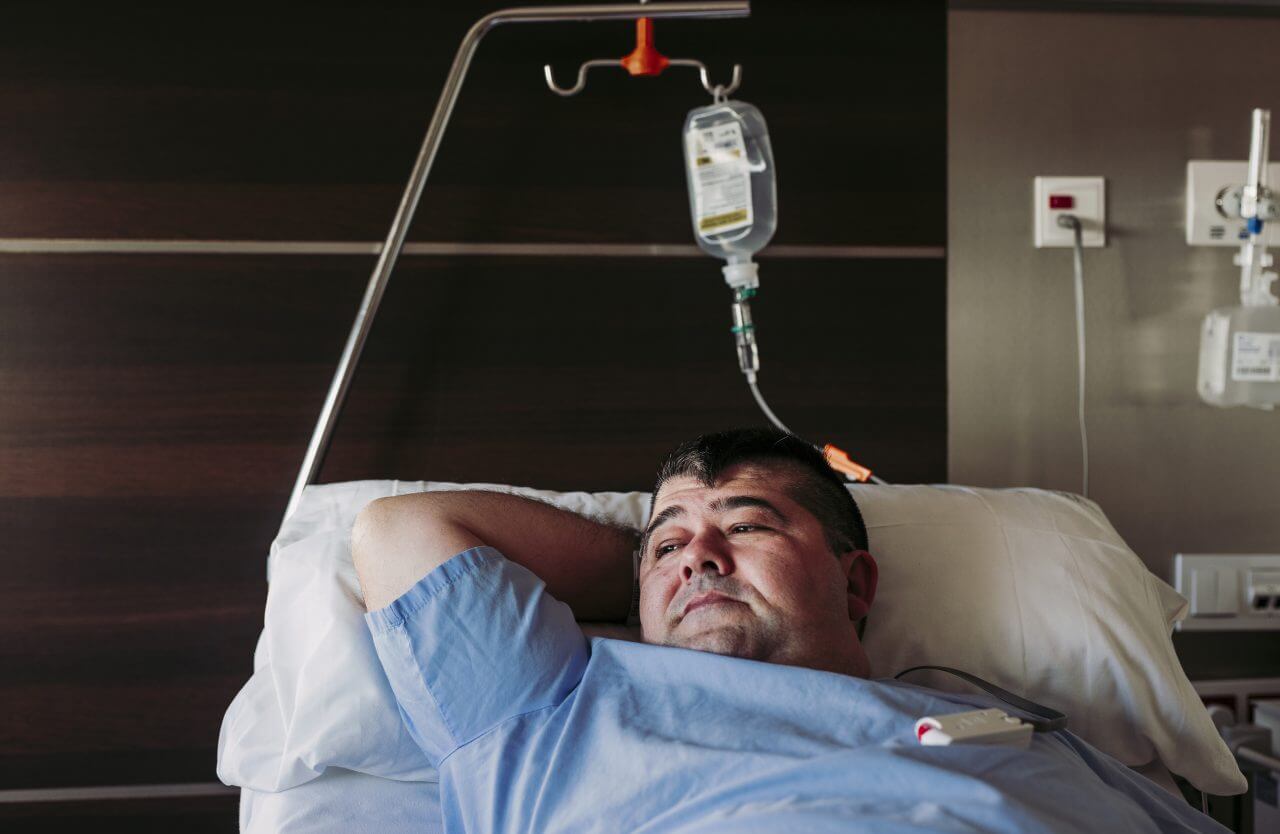 man laying in hospital bed