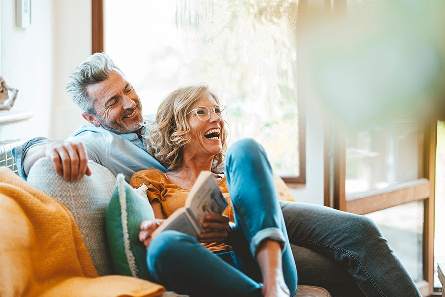 Man and woman on a couch laughing